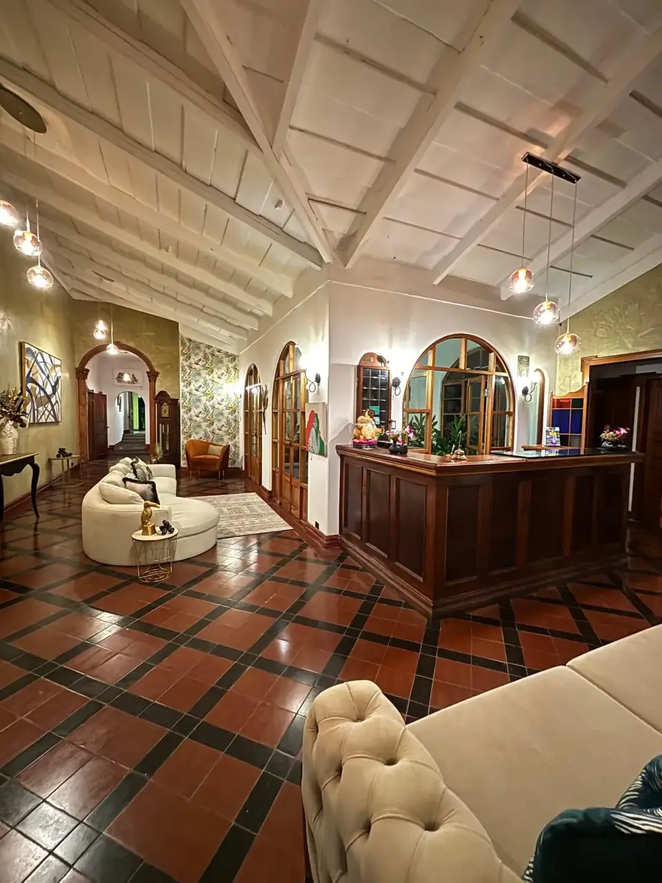 The lobby with terracotta tiles, carved wood reception and arched doorways